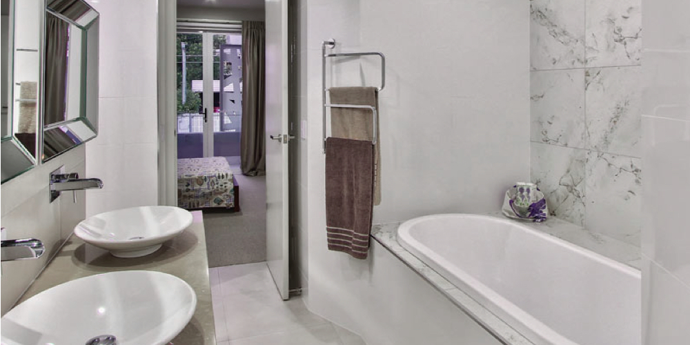 Walk-in shower with marble-look tiles after Accuplumb fit-off