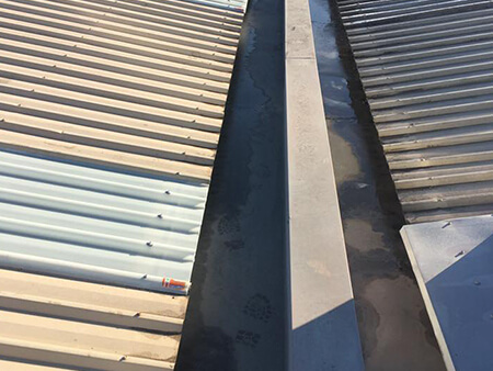 Corrugated roof box gutter inspection on a commercial building